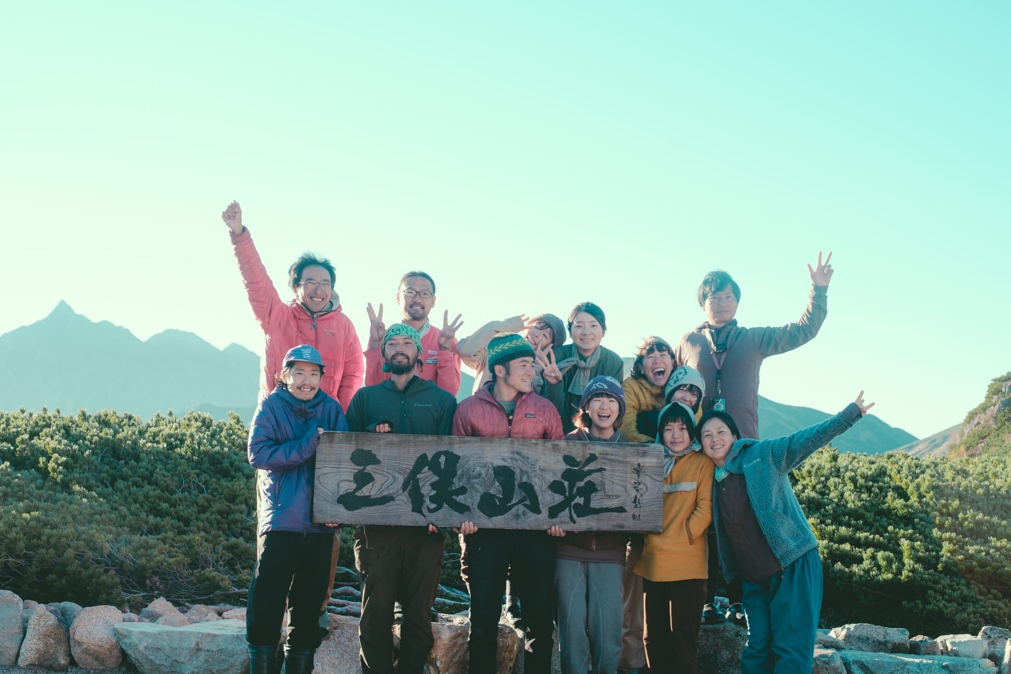 三俣山荘の看板前に集合するスタッフたち