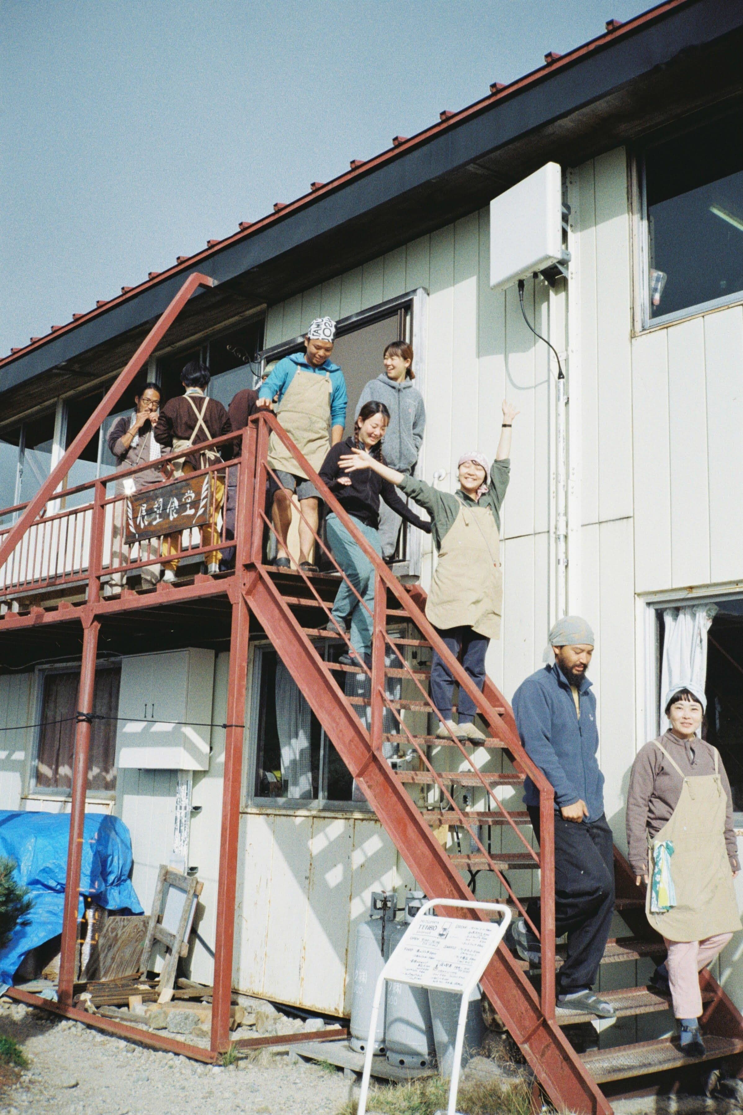 事務所の外階段に集まるスタッフたち