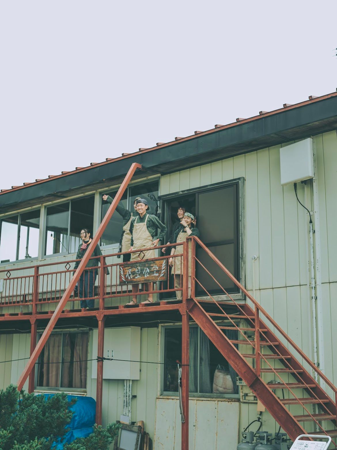 山荘のバルコニーから手を振るメンバー