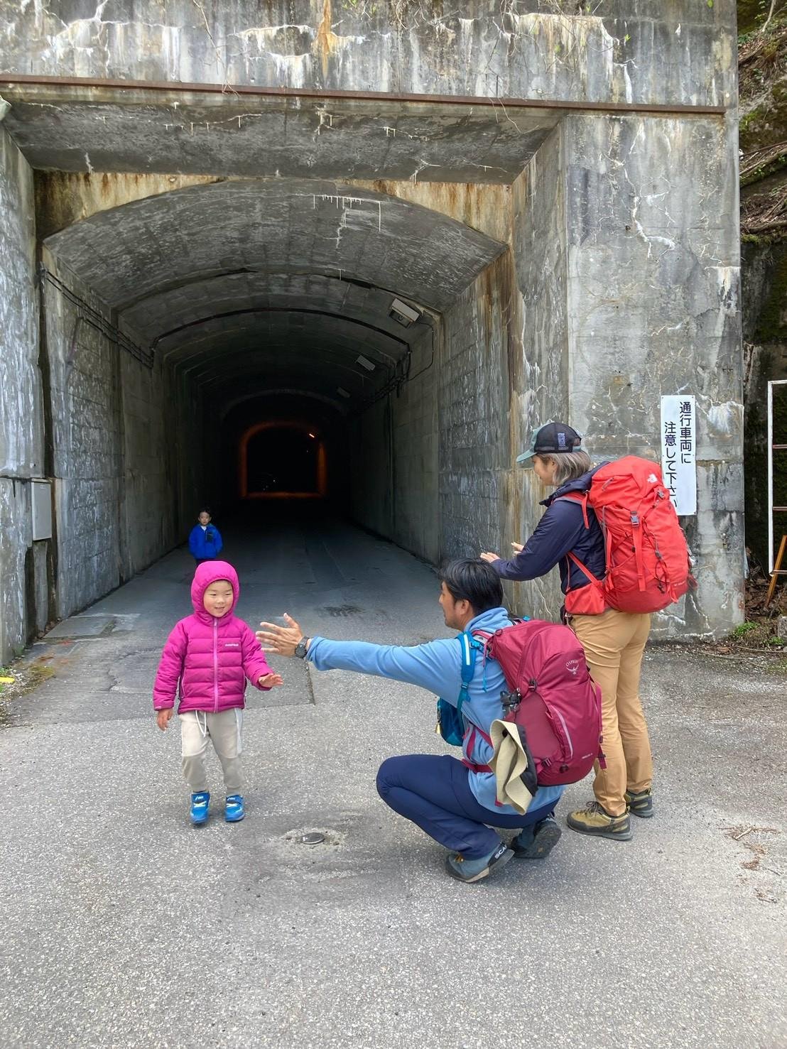 トンネルの出口で子どもを迎えるお父さん