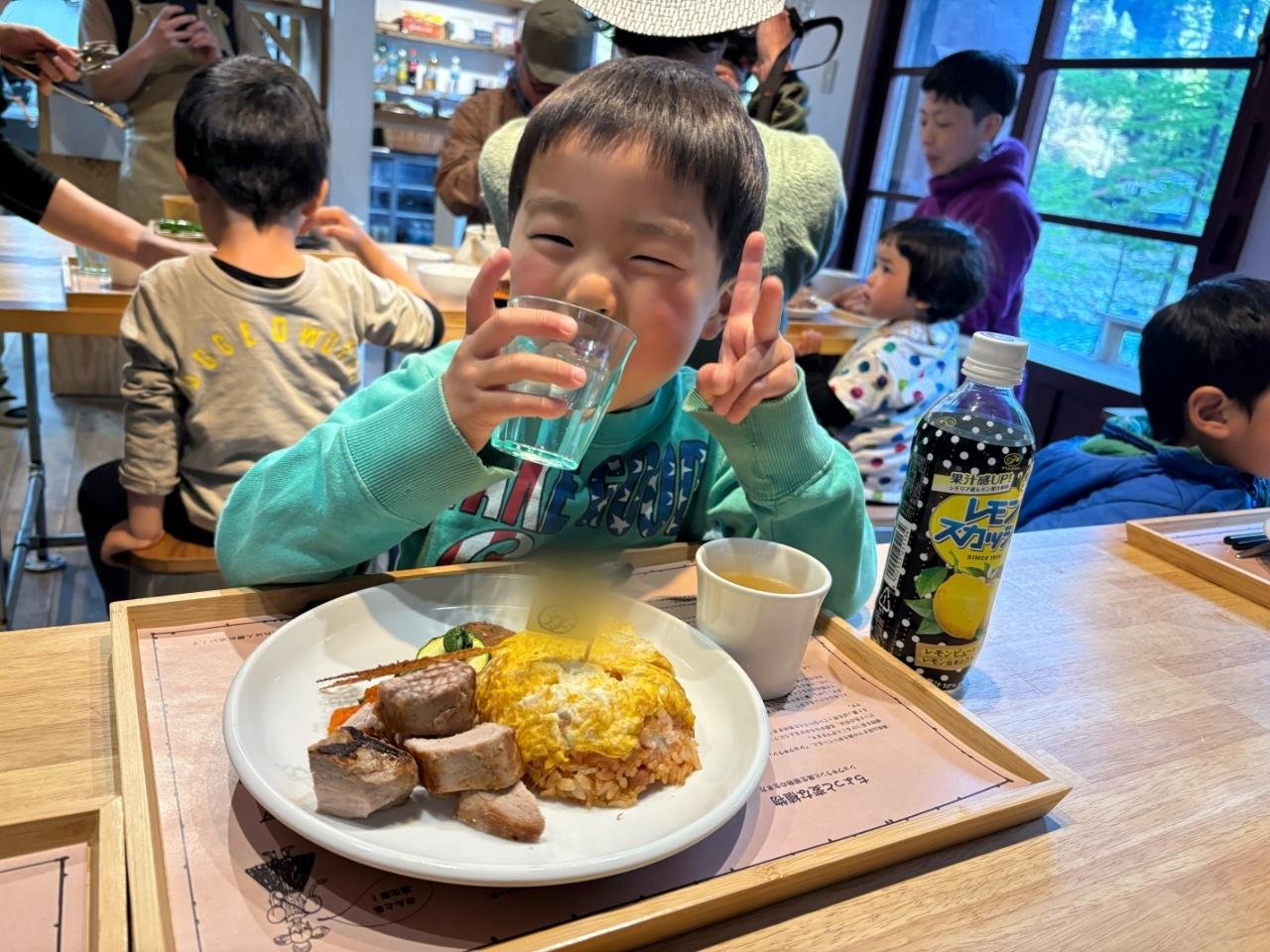 湯俣山荘の食堂で子ども用のオムライスを前に笑う子ども